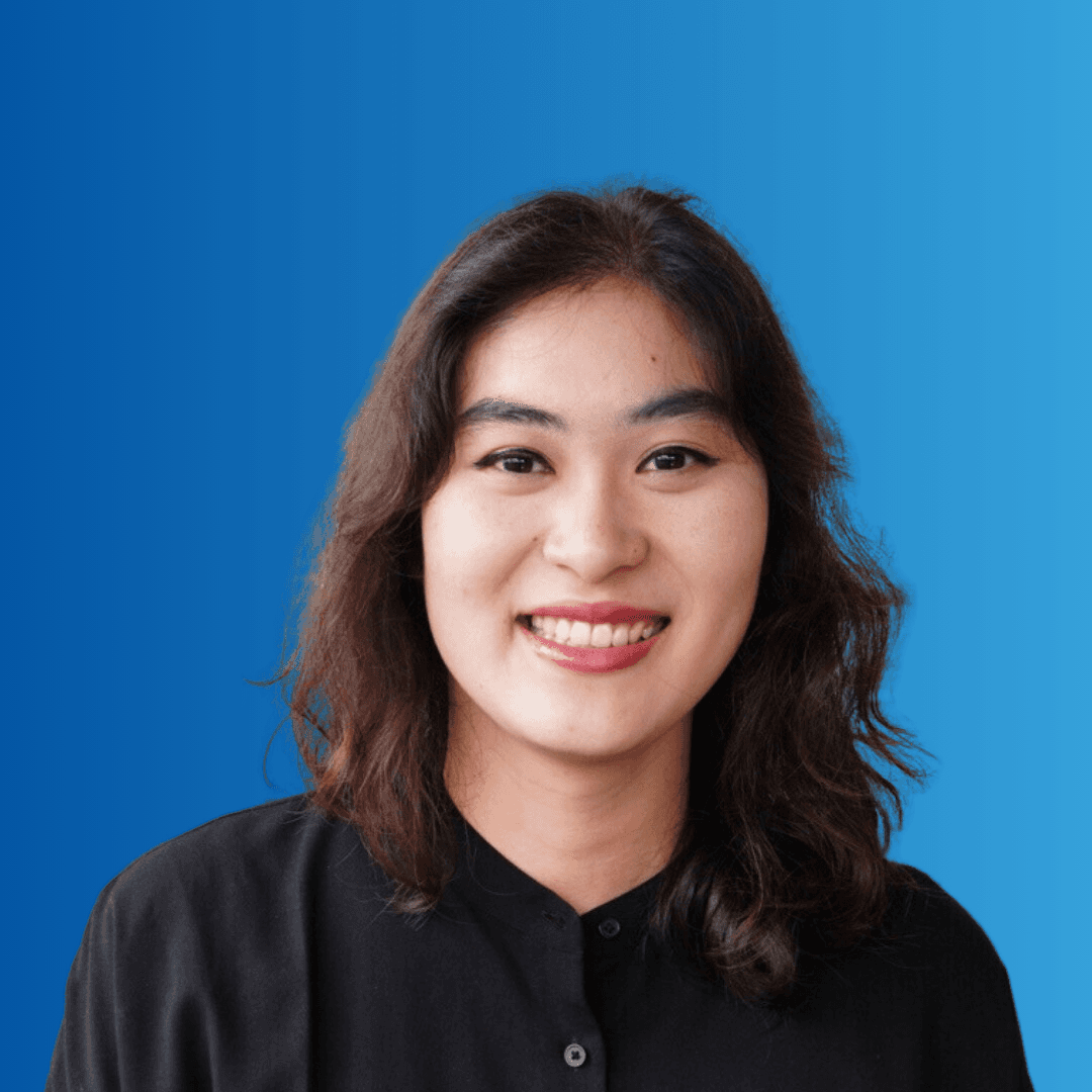 A woman smiling at the camera on a blue background