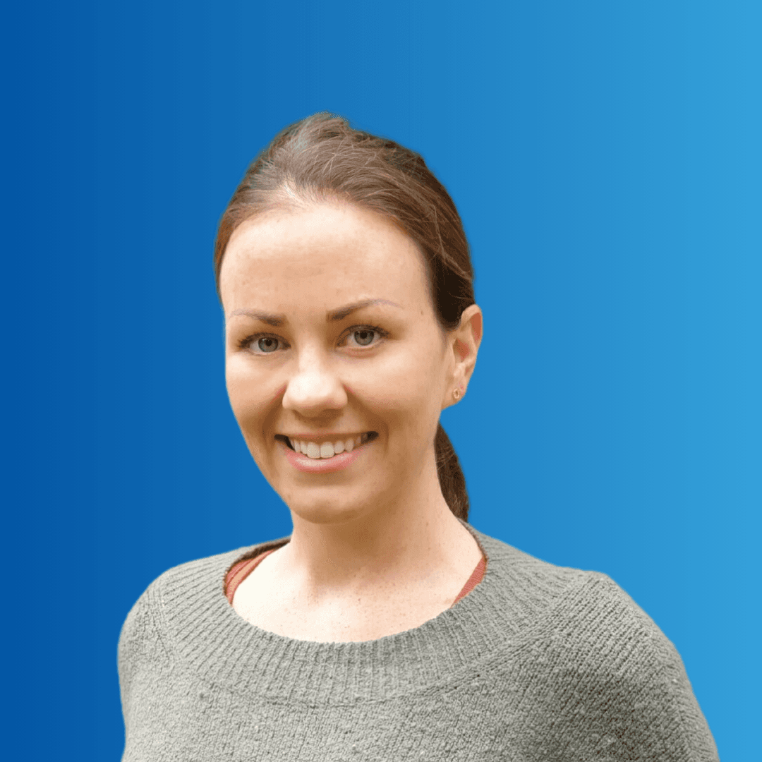 A woman smiling at the camera on a blue background